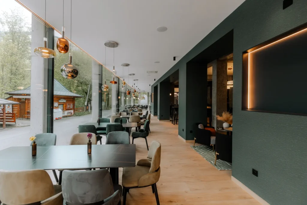 Stoly podél prosklené stěny s výhledem do přírody – restaurace TOK, Hotel Ráztoka
